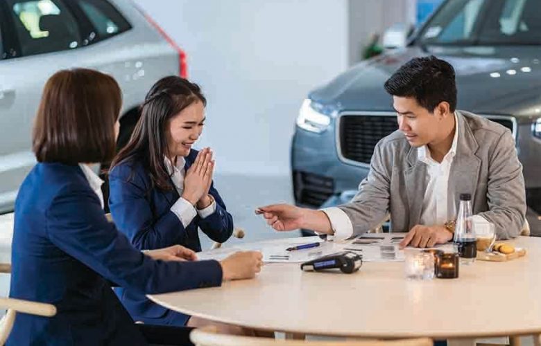 asian women at a car showroom purchasing a new car