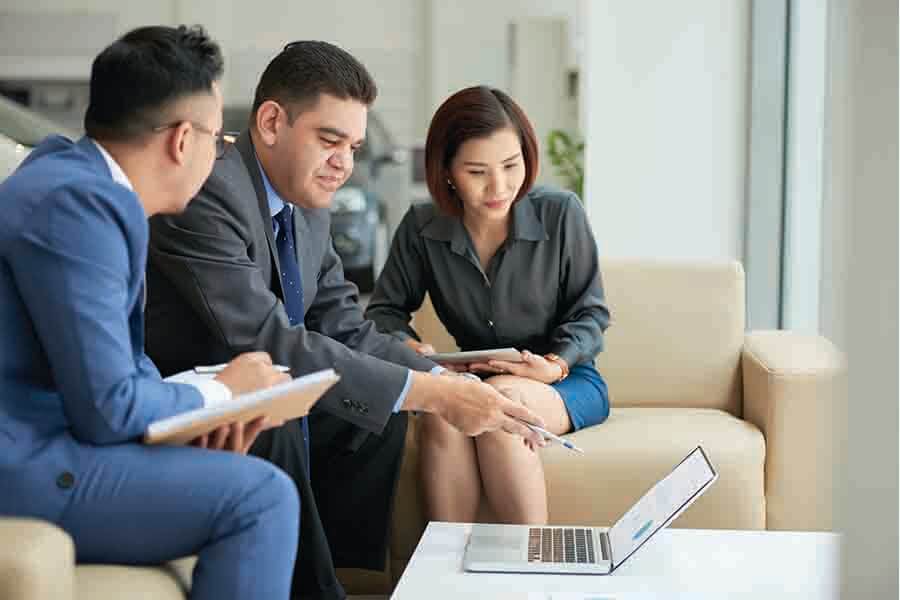 men negotiating the price of car with two car dealer