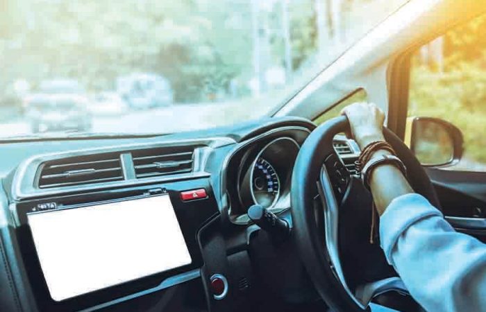 women's hand on the steering wheel making a turn