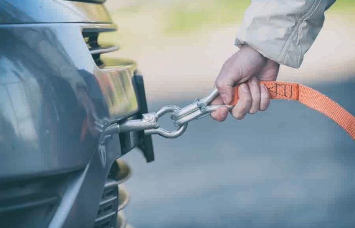women assembling towing line to car tow hook