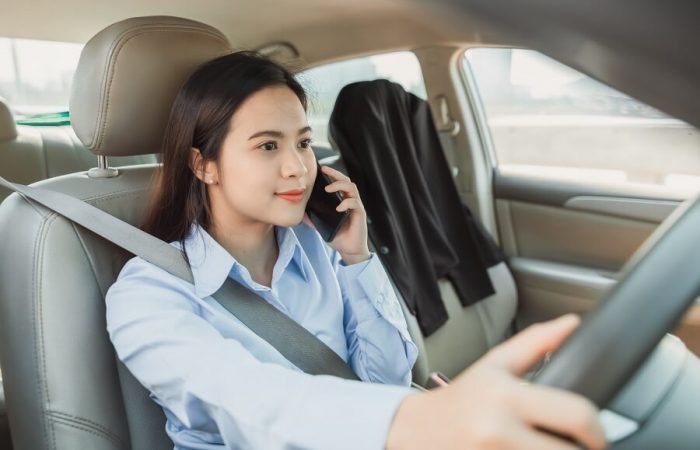 woman using mobile phone while driving