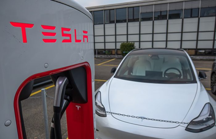 electric tesla model 3 at charging station