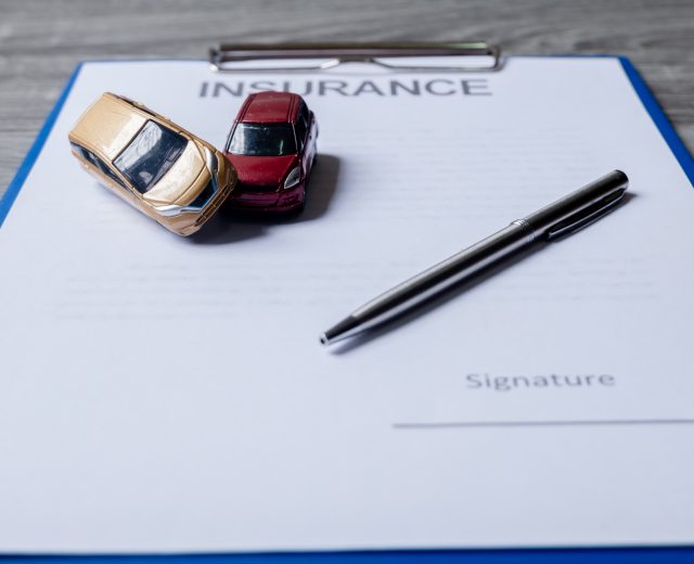 Car and pen on insurance documents