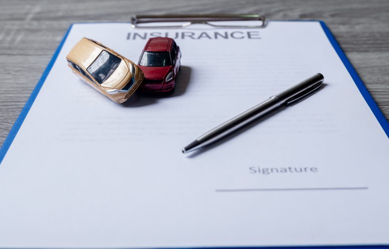 Car and pen on insurance documents