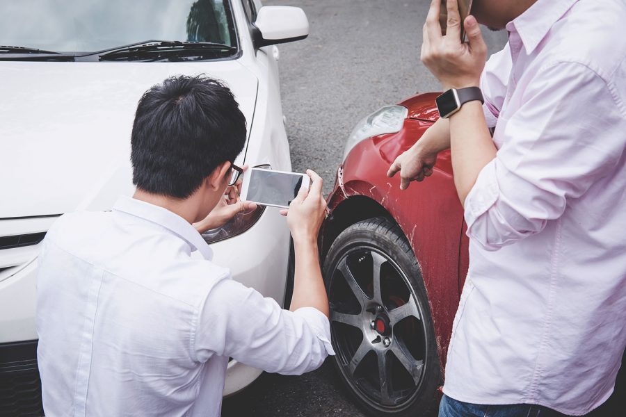 Two drivers man arguing after a car traffic accident collision a Two drivers man arguing after a car traffic accident collision and making phone call to Insurance Agent and take a photo, Traffic Accident and insurance concept.