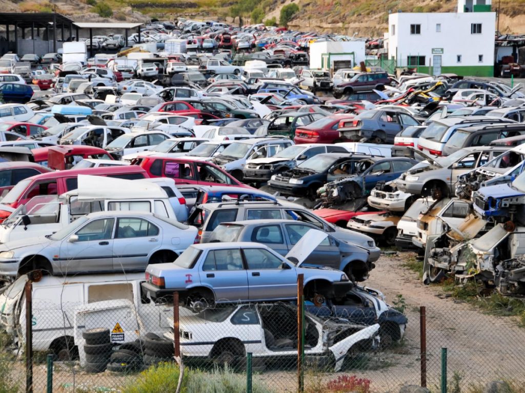 Car scrapyard with stacks junk cars waiting to be scrapped