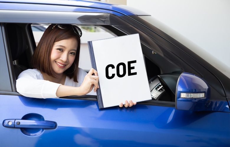 Woman in blue car holding up certificate of entitlement (COE) in Singapore