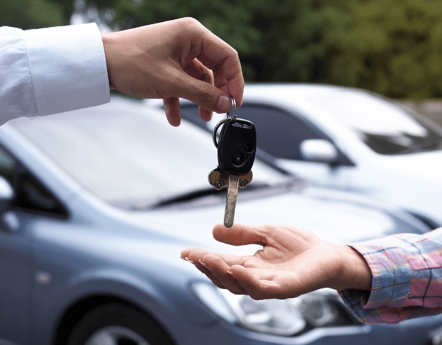 Close-up of a car dealer giving client car keys