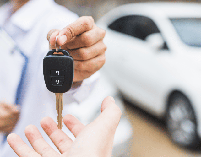 Close-up of a man giving a car key for a buyer