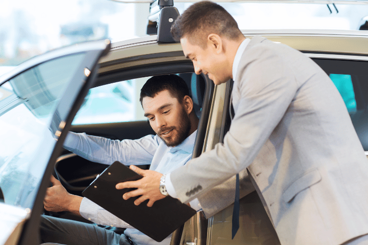 Happy man checking a list with a car dealer